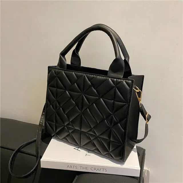 a black purse sitting on top of a white box
