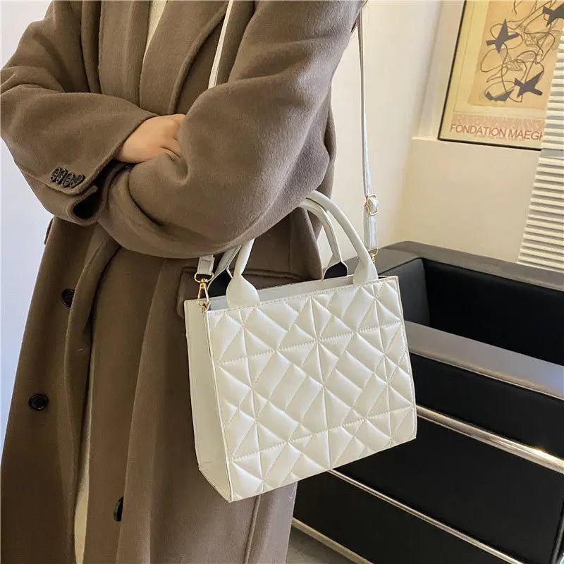 a woman holding a white purse in her hands